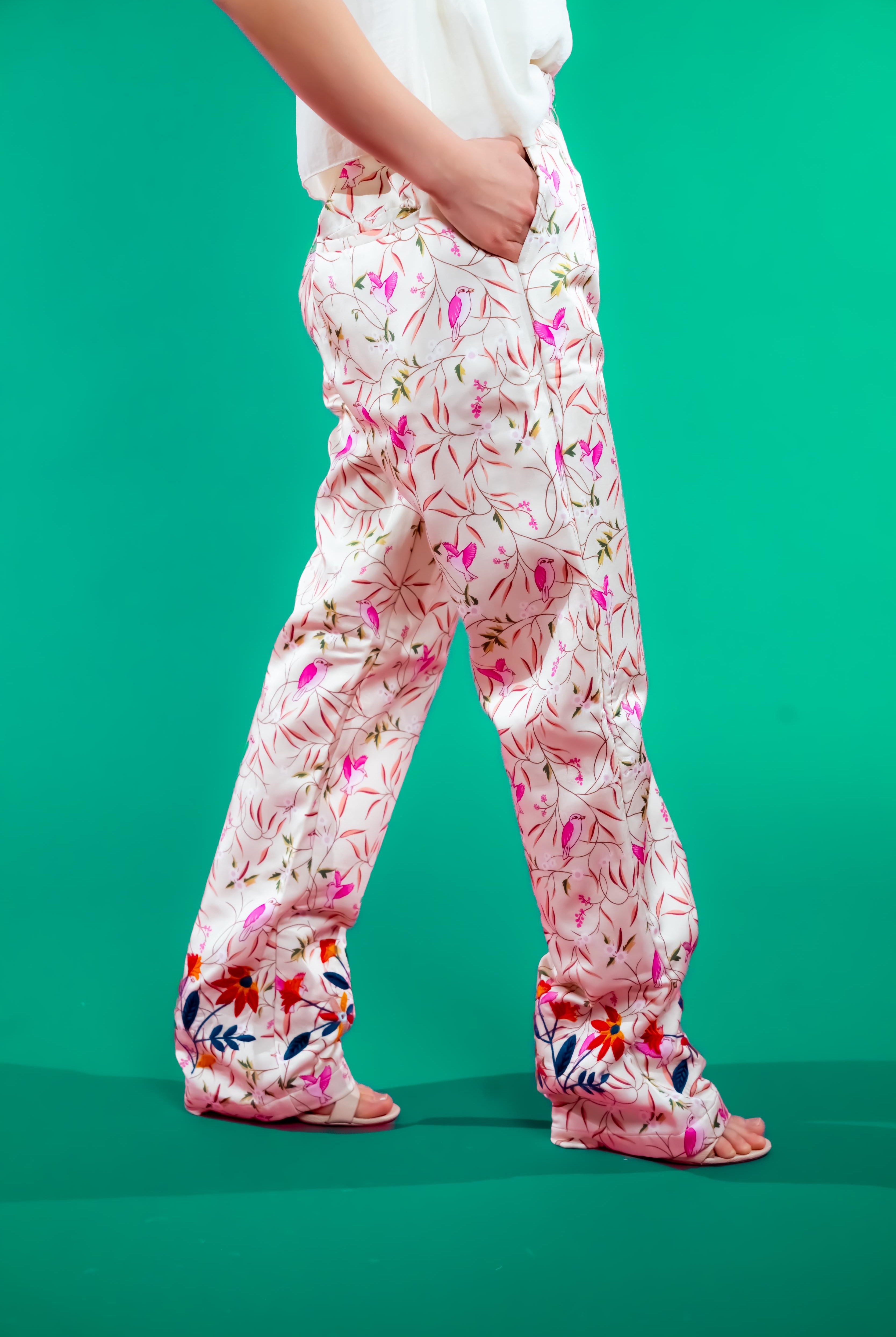 Straight-leg pants with unique bird print and vibrant hand-embroidered hems, designed for comfort, elegance, and sustainable style.