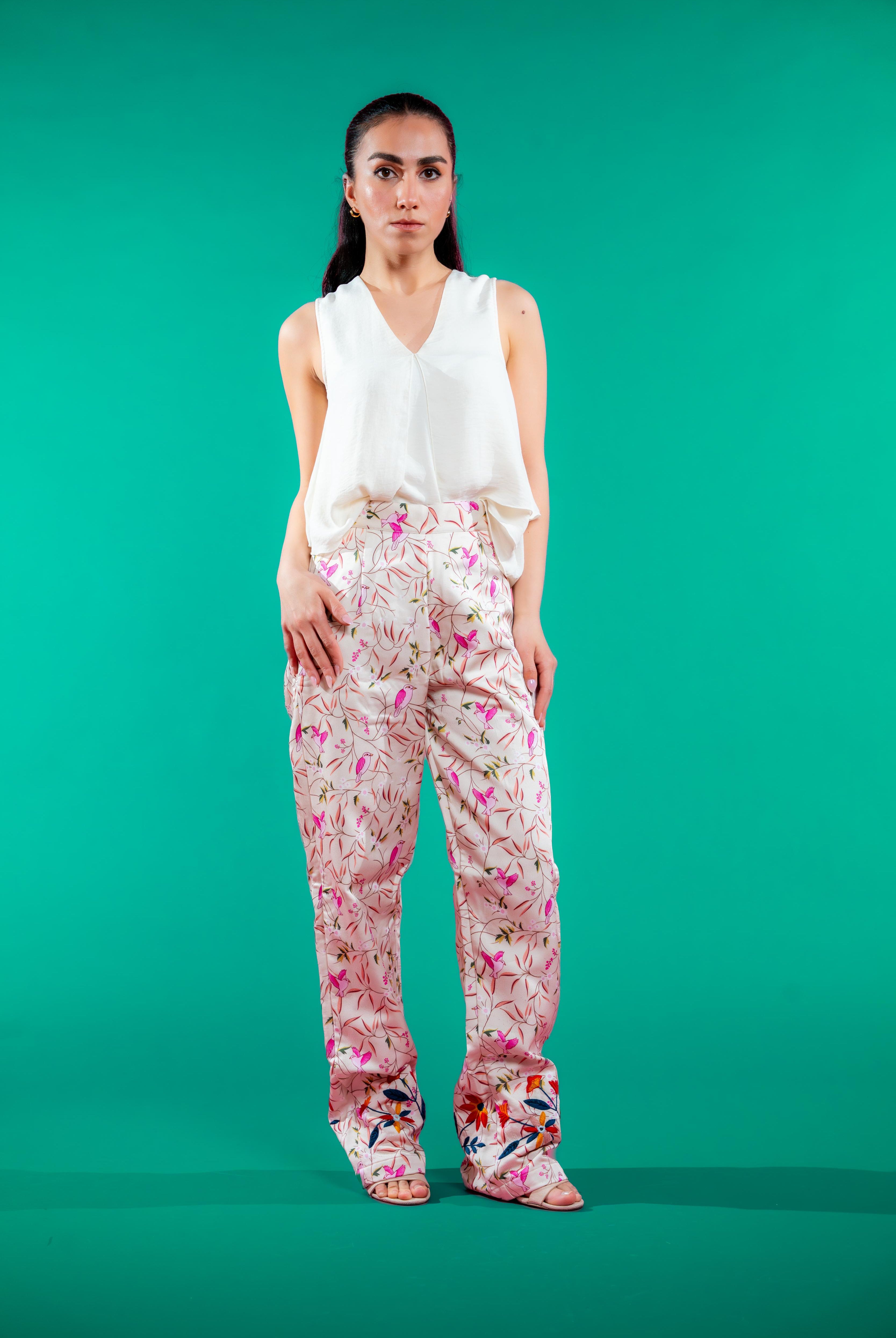 Straight-leg pants with unique bird print and vibrant hand-embroidered hems, designed for comfort, elegance, and sustainable style.